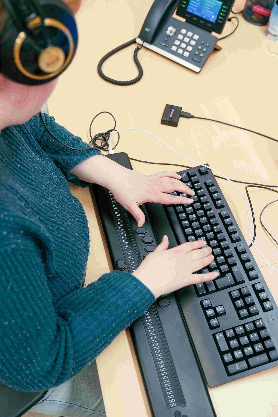 Screenreader-Tester:innen Eine Frau bedient einen PC mittels Brailletastatur und Screenreader