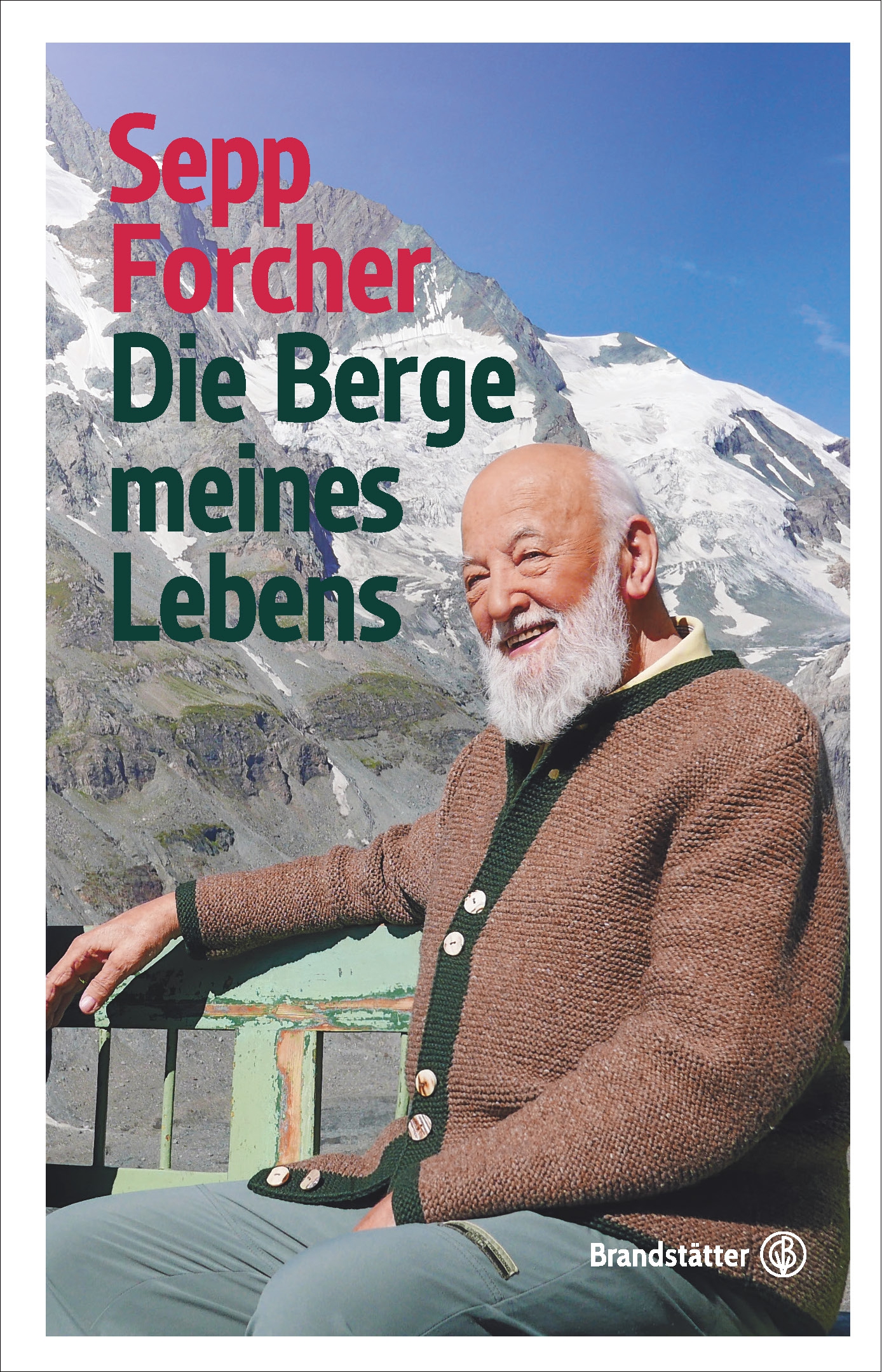 Sepp Forcher am Buchcover: Die Berge meines Lebens. In der Sonne sitzend vor Bergpanorama © Brandstätter